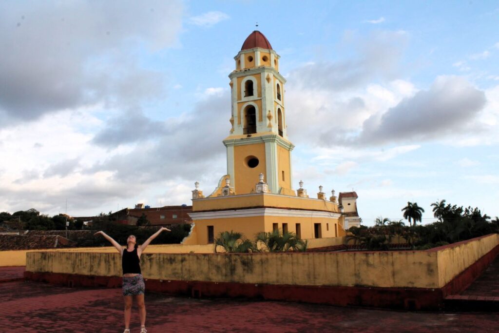lady on rooftop trinidad with church behind